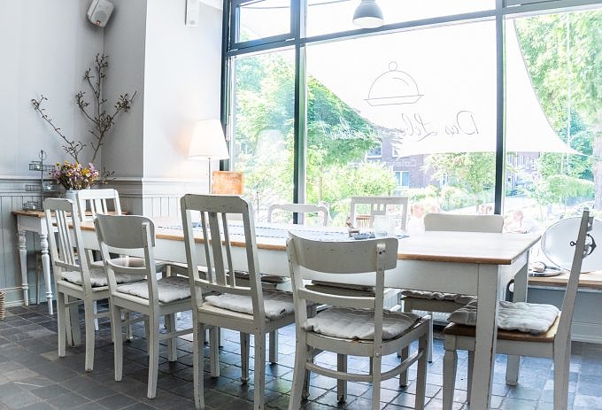 Ein langer weißer Tisch mit Stühlen im Das Leben isst schön in Volksdorf.